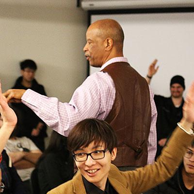 students raising hands in a small classroom